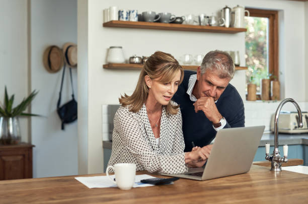 Senior or adult with laptop planning home sale